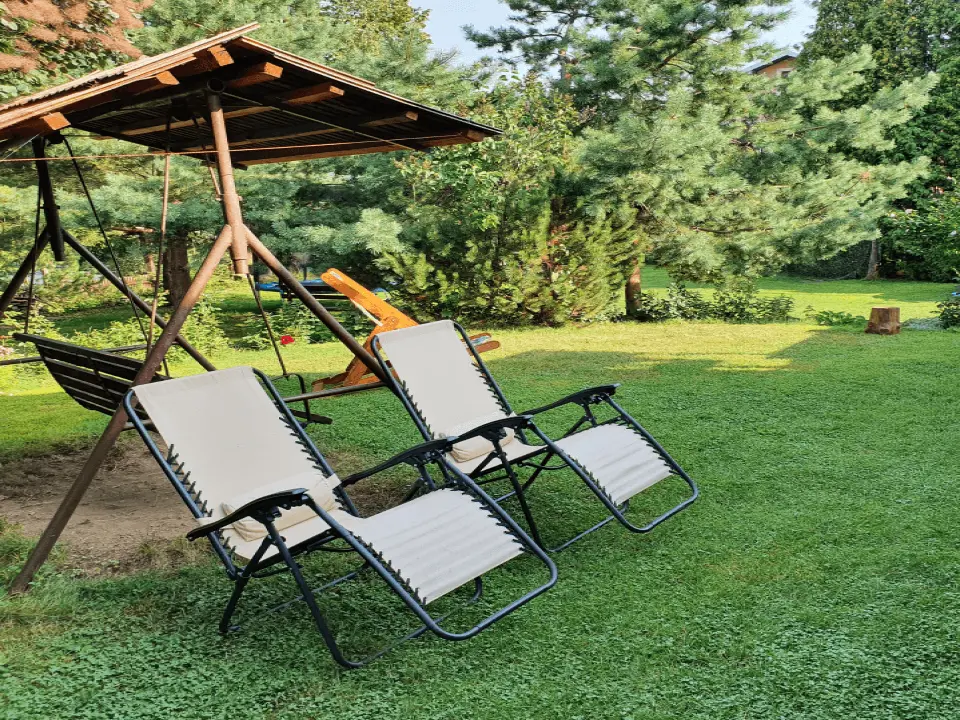 Wejście do karpackiego dworku od strony ogrodu oraz dwa rozłożone leżaki