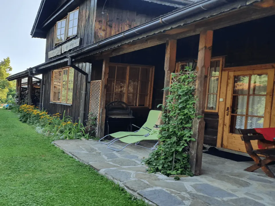 Wejście do karpackiego dworku od strony ogrodu oraz dwa rozłożone leżaki
