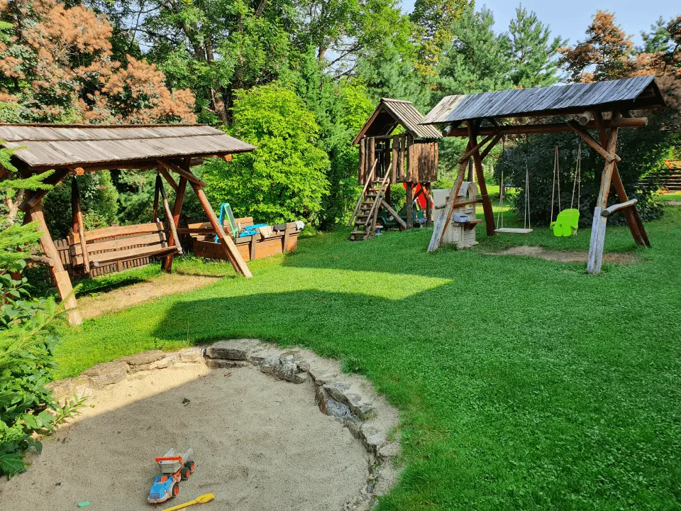 Wejście do karpackiego dworku od strony ogrodu oraz dwa rozłożone leżaki