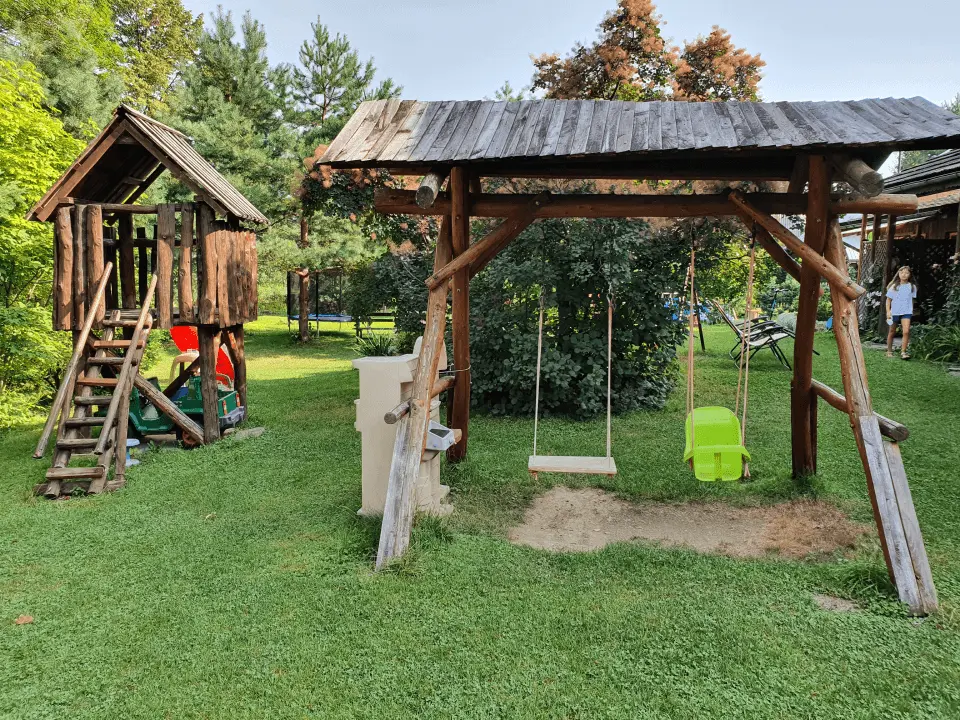 Wejście do karpackiego dworku od strony ogrodu oraz dwa rozłożone leżaki