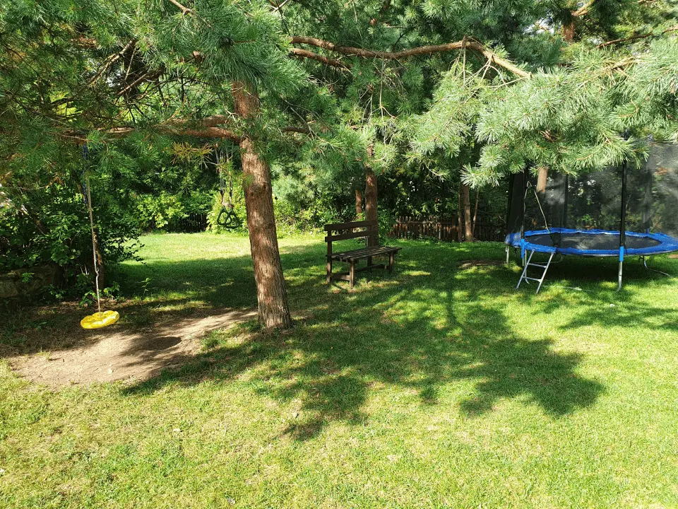 Wejście do karpackiego dworku od strony ogrodu oraz dwa rozłożone leżaki