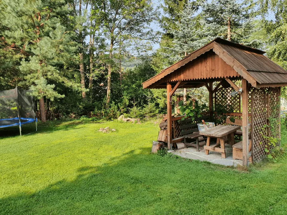 Wejście do karpackiego dworku od strony ogrodu oraz dwa rozłożone leżaki