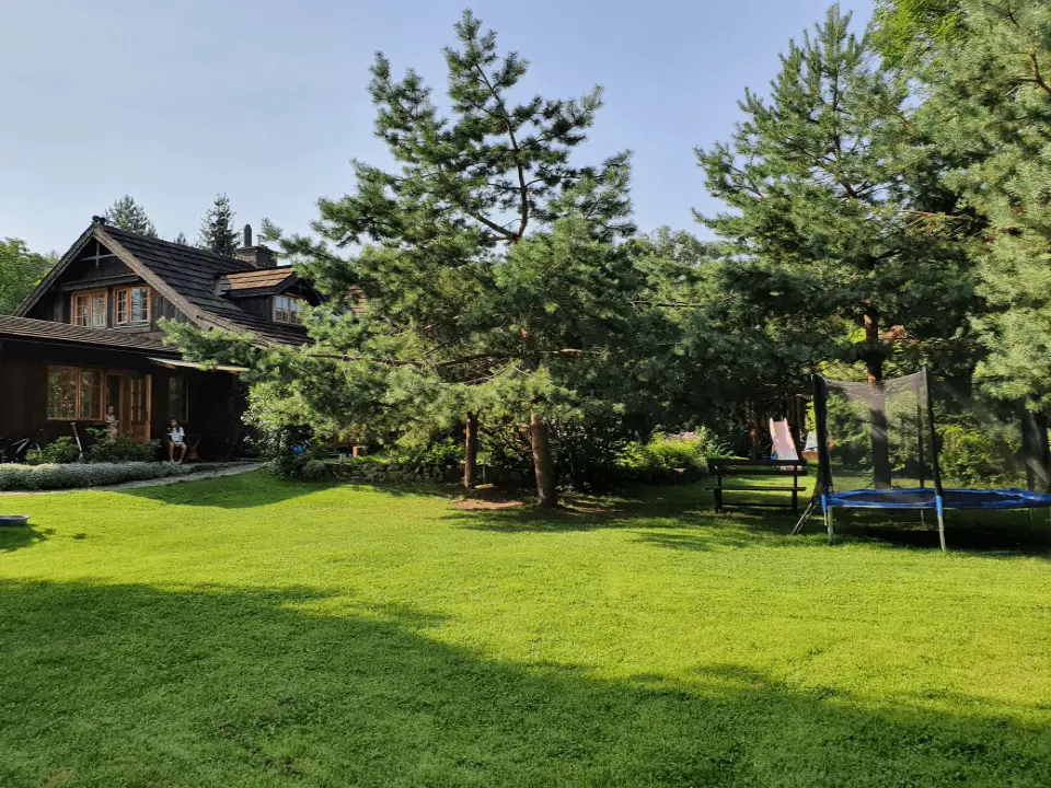 Wejście do karpackiego dworku od strony ogrodu oraz dwa rozłożone leżaki