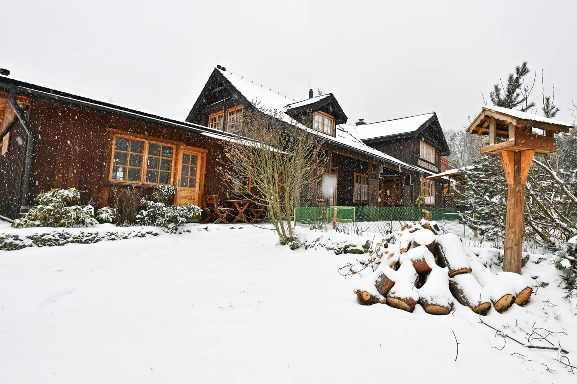 Wejście do karpackiego dworku od strony ogrodu oraz dwa rozłożone leżaki