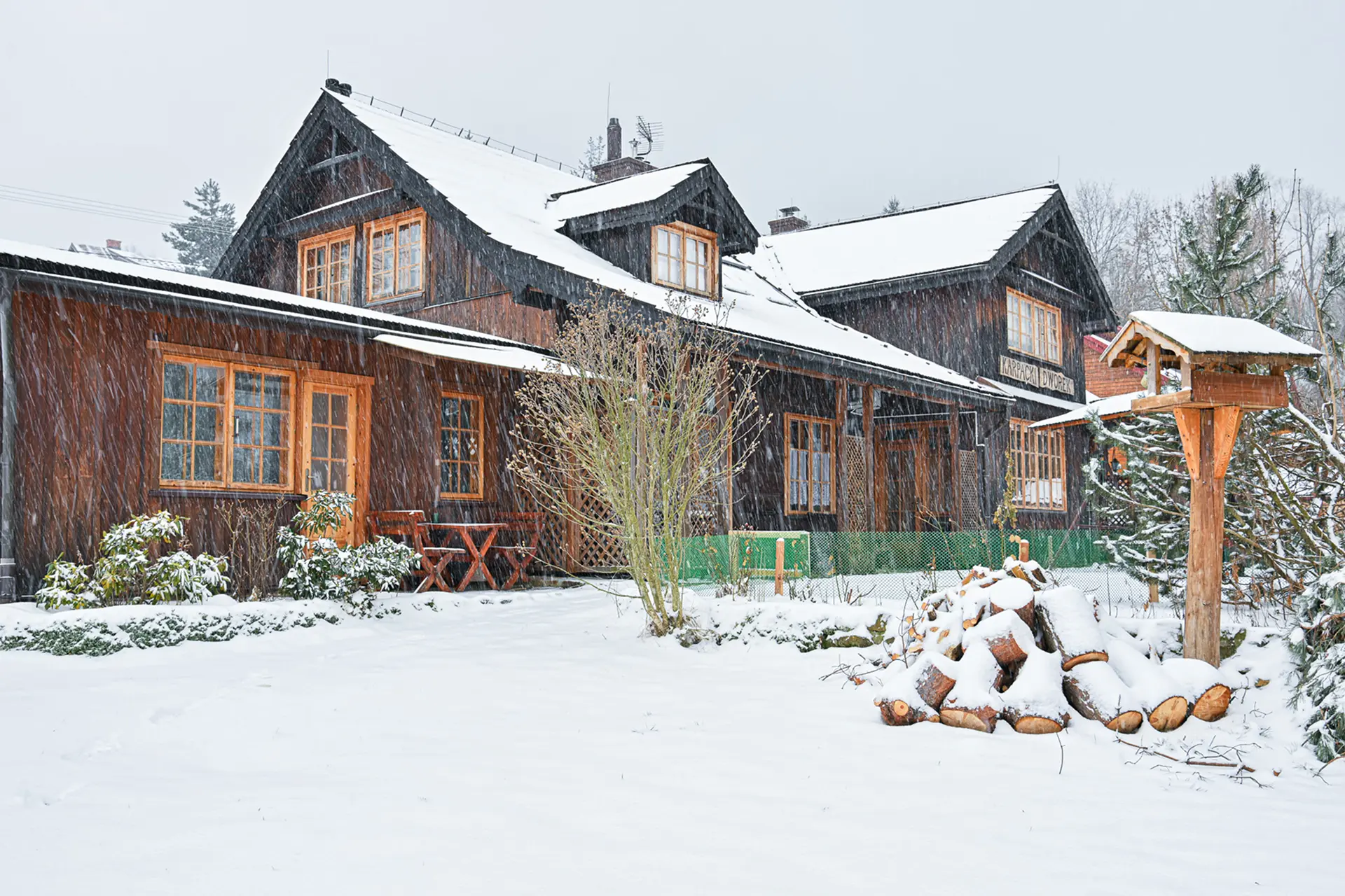 Wejście do karpackiego dworku od strony ogrodu oraz dwa rozłożone leżaki