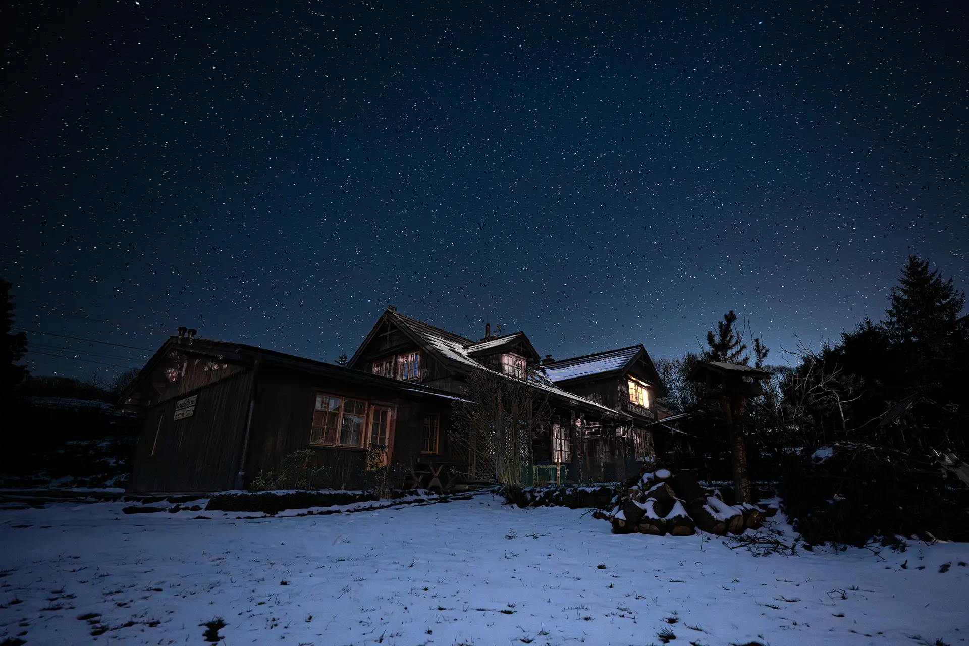 Wejście do karpackiego dworku od strony ogrodu oraz dwa rozłożone leżaki