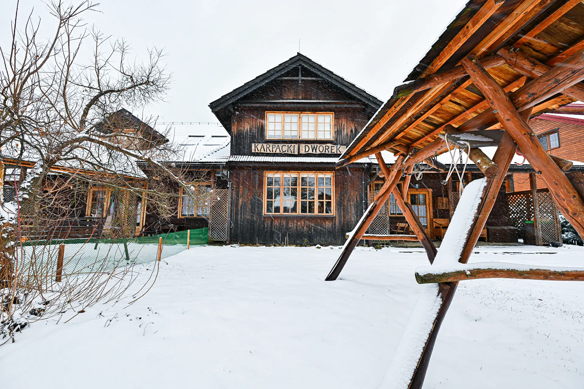 Wejście do karpackiego dworku od strony ogrodu oraz dwa rozłożone leżaki