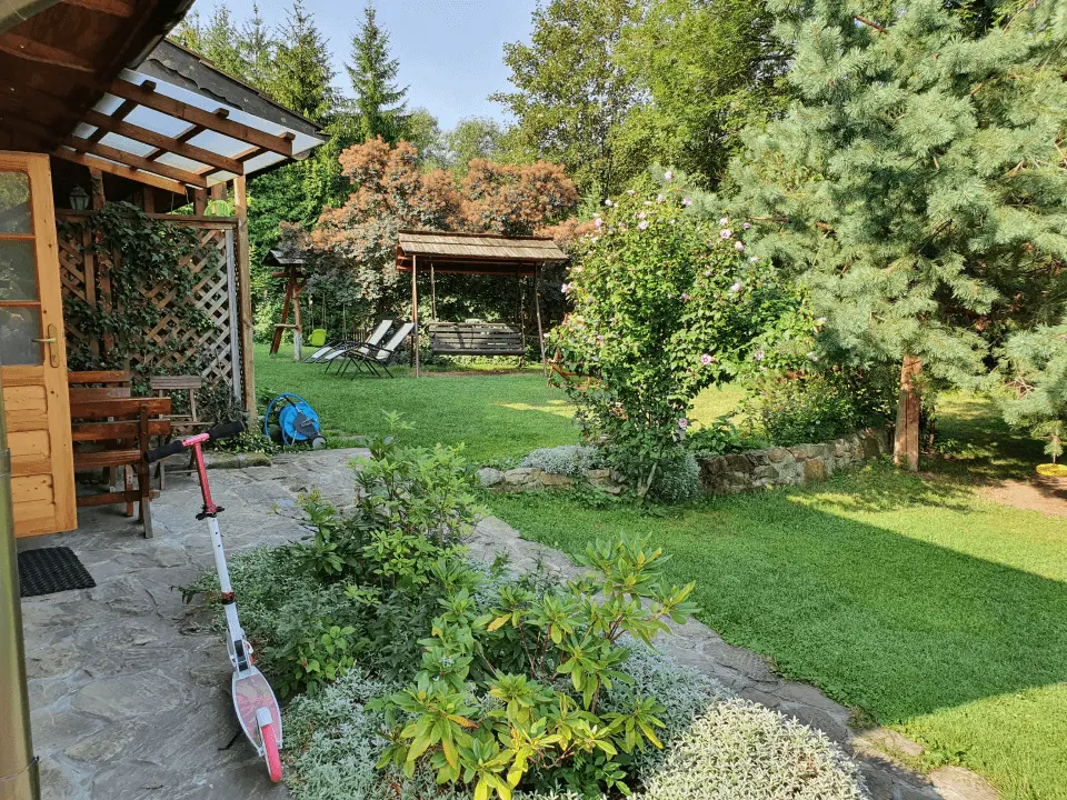 Wejście do karpackiego dworku od strony ogrodu oraz dwa rozłożone leżaki