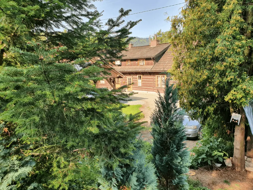 Wejście do karpackiego dworku od strony ogrodu oraz dwa rozłożone leżaki