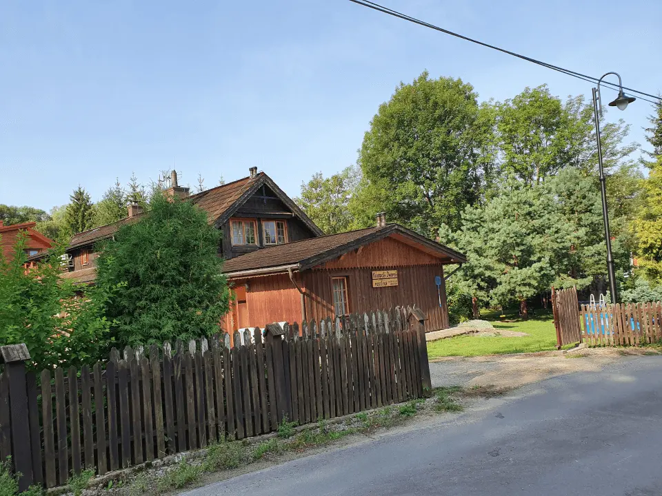 Wejście do karpackiego dworku od strony ogrodu oraz dwa rozłożone leżaki