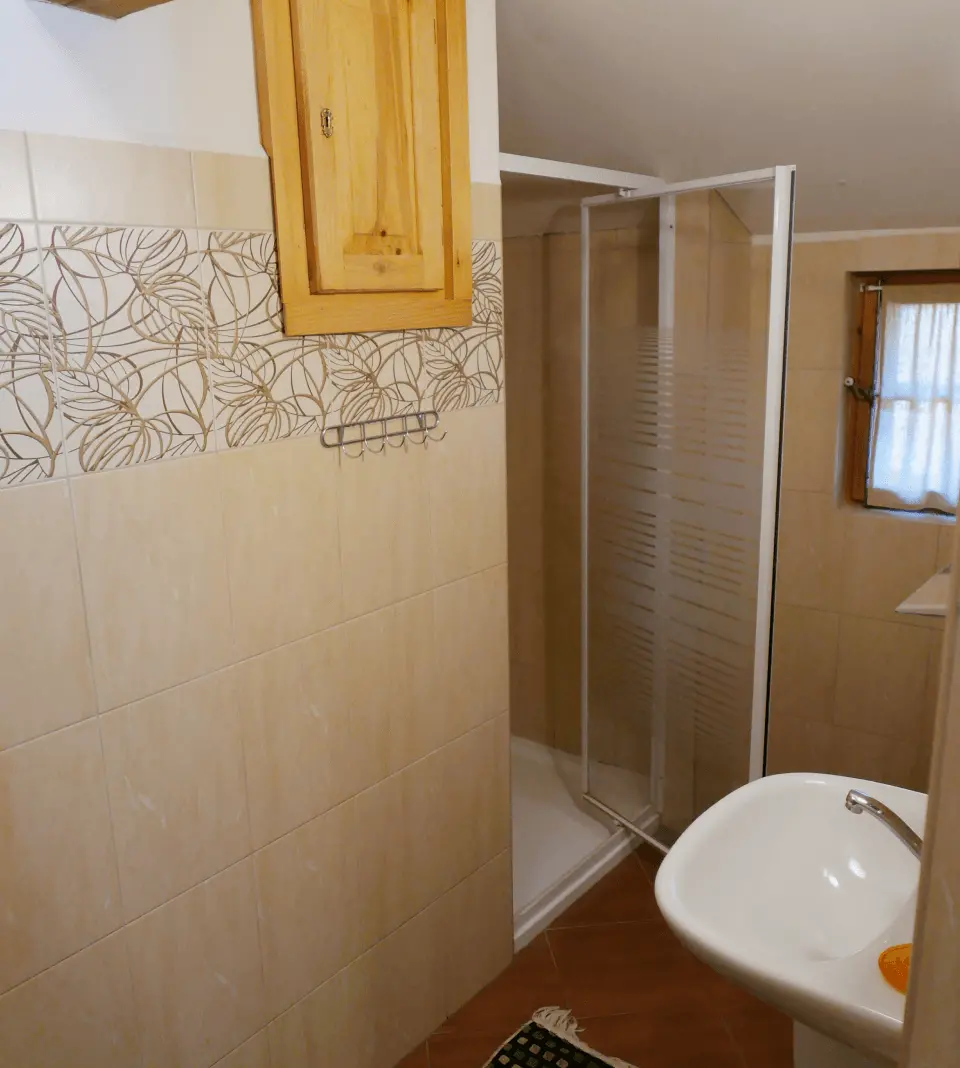 Łazienka z kabiną prysznicową, oknem i umywalką