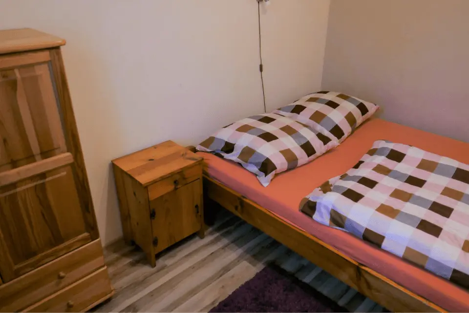 Sypialnia z łóżkiem, nakastlikiem oraz szafą na najpotrzebniejsze rzeczy gości